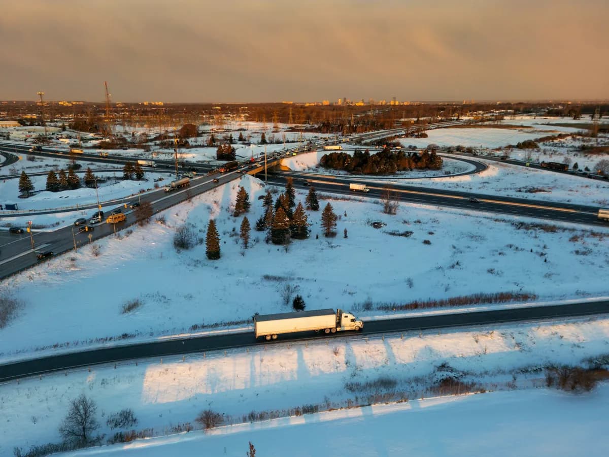 Transport truck on a snowy highway at sunset