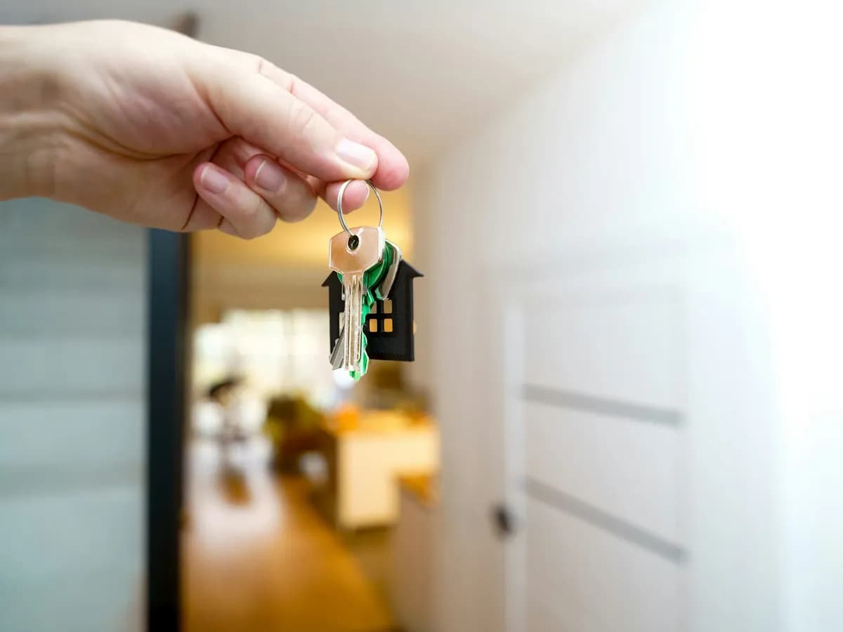 A hand holding a set of house keys